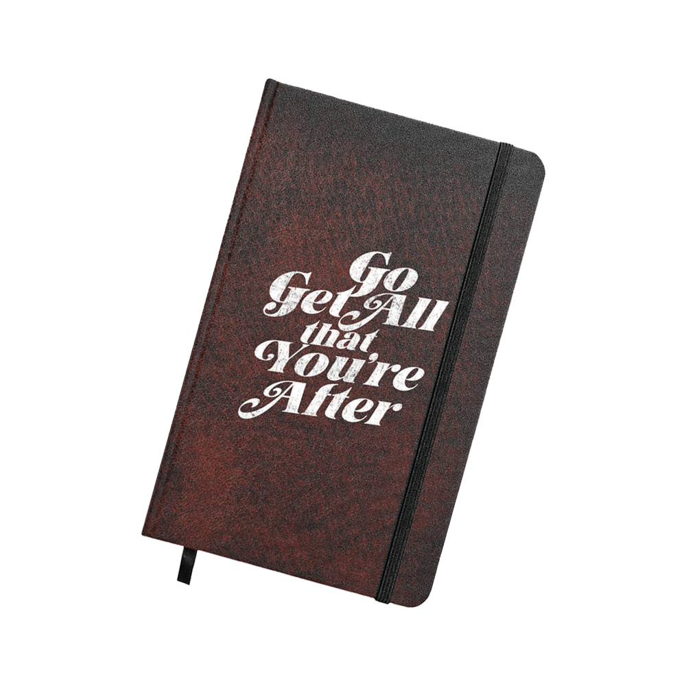 Maroon textured journal with bold white vintage-style lettering reading “Go Get All that You’re After,” secured with a black elastic strap.